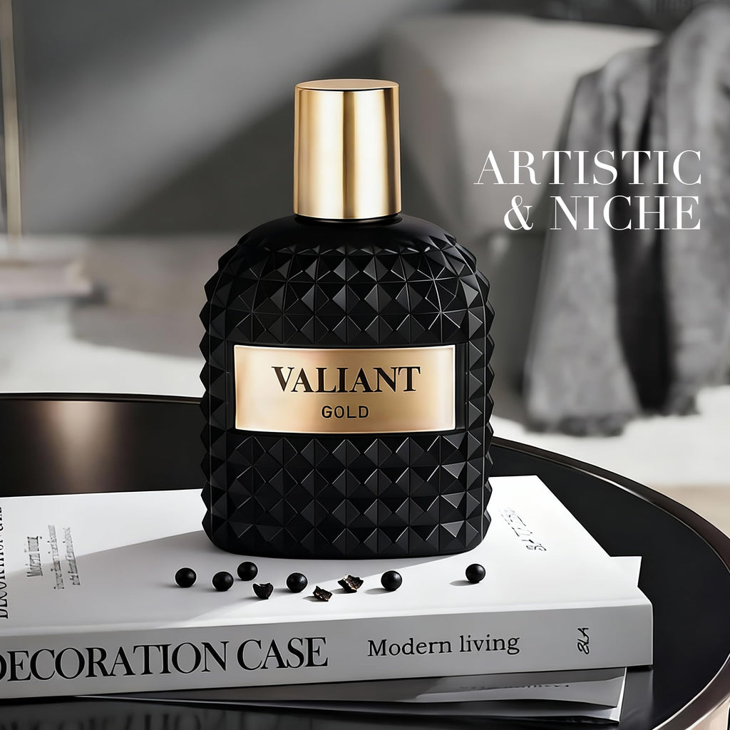 Black and gold 'Valiant Gold' perfume bottle on a book with 'Artistic & Niche' text.